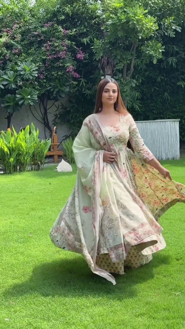 A graceful floral ethnic outfit in soft pastel shades, featuring delicate prints and a flowing silhouette. The outfit is paired with a matching dupatta