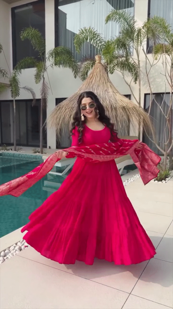 Radiating Joy in a Vibrant Red Flowing Dress, Twirling Gracefully by the Poolside with a Matching Red Dupatta and Trendy Sunglasses, Exuding a Fun and Chic Vibe